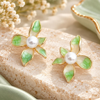Green and white floral stud earrings with pearl centres and gold-tone outlines | SISTERHOODS-SHA256:839f6e626da4d29c5ab4d0362ac8d790a751fc61c89315f15b07af81465d530c