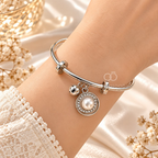 Silver adjustable bracelet with pearl circular charm and sparkling accents | SISTERHOODS-SHA256:4b5e4fcbc64a709ef5f411534cb3ef3833a8640f04d497c3ce5aae1b786b937a