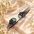 Ornate oxidized cuff bracelet with teal and pink accents | SISTERHOODS-SHA256:3ab232a76f274a29d141f465514f4b6595497de9ca73ba9c87dca05cc2b4702a