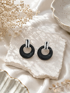 Glossy black circular hoop earrings with silver-tone rectangular tops | SISTERHOODS-SHA256:24a0abe3f0d75a8c54690344b4f33ee3e9a995af0581166a510c0539c8b6df52