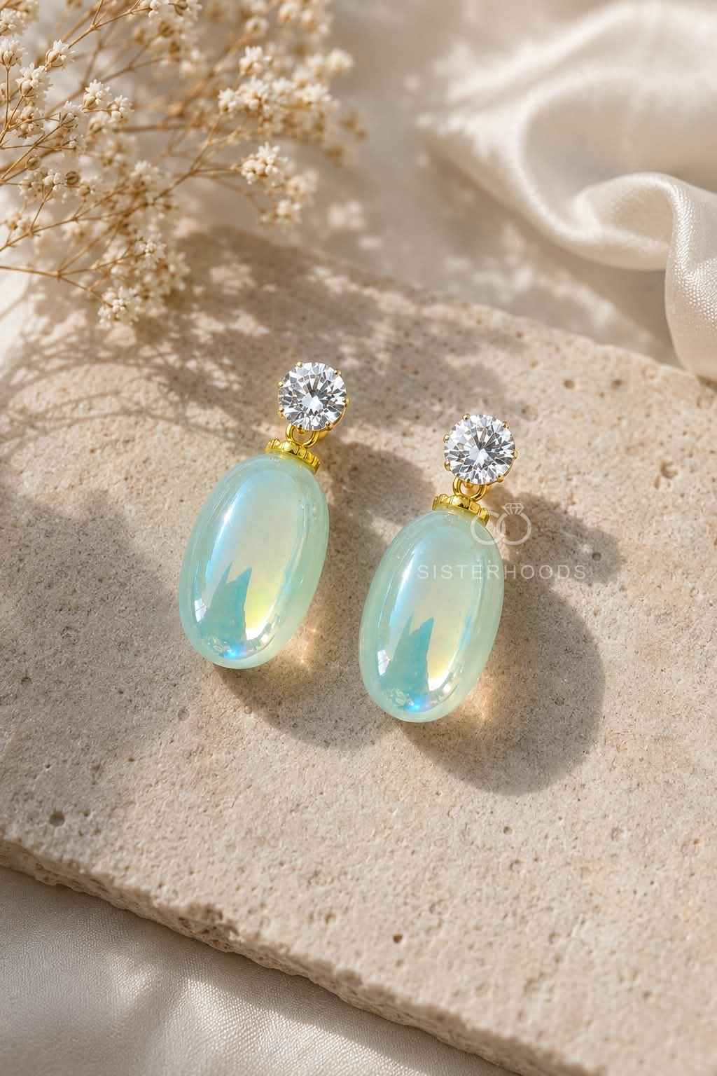 Pale aqua oval drop earrings with clear faceted round accents and gold-tone details | SISTERHOODS-SHA256:a2dde375d366884471bef1d586c1fff9d76de0481eb6825197cbdcd753189962