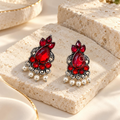 Red oxidized dangle earrings with leaf details and cascading white pearl-style drops | SISTERHOODS-SHA256:0b9dbd2845bffd45651fe864f3a8ba6ffca7e5fa43fcc6f441f273e8166c0eb1
