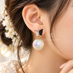 Butterfly stud earrings with black and pink wings and iridescent pearl drops | SISTERHOODS-SHA256:7af5517e0c1b67d880de0ac384f0f0665745ad542d25d3f82e6b8c6a3d28edcd