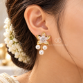 Gold-coloured floral dangle earring with white pearl drops and a sparkling centre accent | SISTERHOODS-SHA256:2596ed012c4d928ee27dfae647d6dfb784d20eed10c3b63ae6543eab2c6c8433