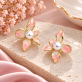 Pink flower-shaped stud earrings with pearl-style centres and gold-tone outlines | SISTERHOODS-SHA256:43b1963dfda366bde7dda649a76f1144abe7363fbdf15748224fd0118533a28f