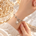 Silver adjustable bracelet with pearl charm, clear accents and bead detail | SISTERHOODS-SHA256:05181ef908ae7610c915717cdf421bd5500d17ed531adcb773ad045ad755ed9b