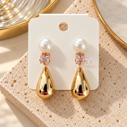 Gold drop earrings with white pearl tops, square crystal accents and polished teardrop pendants | SISTERHOODS-SHA256:f531b6dd14867225264bd989f5cc49ccb0fec58f897021aadd459d830de2f382