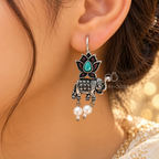 Oxidized silver-tone elephant and lotus dangle earrings with green centre detail and white pearl drops | SISTERHOODS-SHA256:ff0d24f6d414528dd2259ac1e2a39a3ae8274b14bd8595a9bf201a831bc329fe