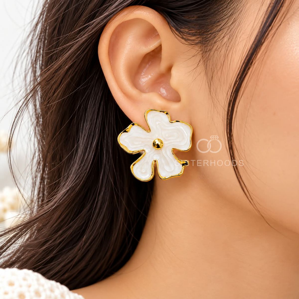 White blossom-shaped gold-tone stud earring worn on an ear | SISTERHOODS-SHA256:4871f247b650aa4756377d8c538ef307b06d741202757feeab30bd9a89465fc5