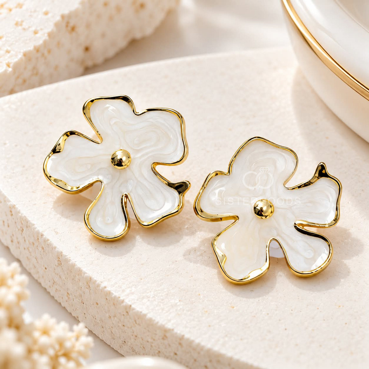 White blossom-shaped gold-tone stud earring worn on an ear | SISTERHOODS-SHA256:52b2abdd8d086ab35f509cdb13ed645dc6993129383a091c3f5c67b8f290c40a