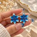 Blue and white floral stud earrings with gradient petals | SISTERHOODS-SHA256:989498cb255d615ec1f2c4215f83059a6c9180155a67d74f3c25b7f1d489c13b