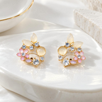Floral stud earring with blush pink, cream and gold-tone petal details | SISTERHOODS-SHA256:52f50b9b94db98328d6f00891ab8cf34b0f7cc5cc66fc47ea633bfef1697f44e