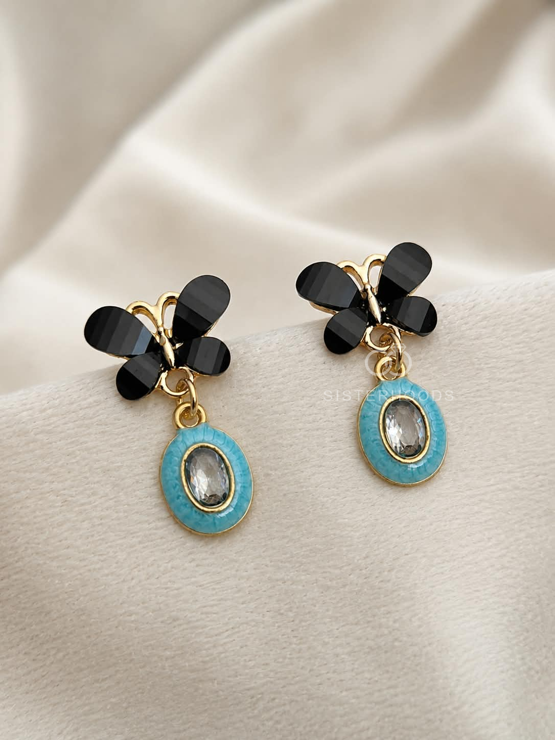 Black floral drop earrings with turquoise oval pendants and clear centres | SISTERHOODS-SHA256:e5e7a15a2bc239f6a8feb0c2bcb3505356b9717a49e86e43da35464b16010ec3
