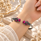 Ornate open cuff bracelet with pink accents and detailed silver-tone motifs | SISTERHOODS-SHA256:6460e06965e5e643e8fa0988ed2808e9711bc5e9795b73593532bc15f9cbfa3b