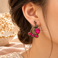 Peacock-inspired oxidized dangle earring with pink accents and curved gold-tone details | SISTERHOODS-SHA256:49a86ac69259a206ff39fc6abe25e4a77c8b1a8124454cf615635ad63df3fde1