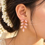 Rose gold toned stud earrings with multiple soft pink leaf-shaped accents | SISTERHOODS-SHA256:f08cde2d18c2645b6879986e823eb54612002329672e183e7ee2fb54e13f16a0