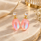Pink iridescent oval drop earrings with clear faceted studs and gold-tone accents | SISTERHOODS-SHA256:da5e7b003179d6ab2ae14de2ef0c1c51eff3e04075e3786dc3fffefc8cf253b6