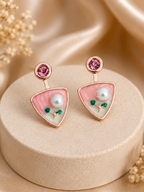 Pink triangular dangle earrings with white bead and green floral accents | SISTERHOODS-SHA256:5294cc37d71ced12b8e07008862242429a23f0a2c0381513a7e4f2594433c76f