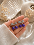 Silver bow earrings with glossy purple cherry-shaped drops | SISTERHOODS-SHA256:758f7c9bf19d0b17258533144b7e7157344da9b3c069d5c6e5568d8b1632f8ed