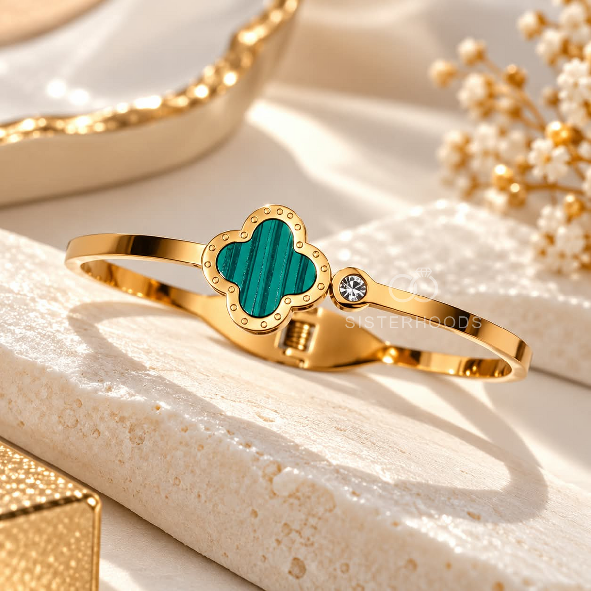 Gold-tone cuff bracelet with a teal quatrefoil centre and small accent detail | SISTERHOODS-SHA256:43d9ccab138ee9de9e82777f8642539e7fe313d6594accf8c213e01af31cf195
