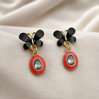 Black wing-shaped earrings with red oval drops and clear faceted centre accents | SISTERHOODS-SHA256:6aa7310b6f83e9390d86becf182c0a141d11faa6aa8c5251fc2aaeaf3563d071