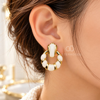 Gold-tone Korean dangle earrings with circular white accents on a model's ear. | SISTERHOODS-SHA256:cc8b8985d67d9955d6f81bbb41bd96f3fff865e3d8df4199a8aeac0e00962327