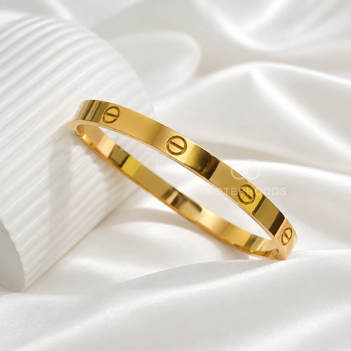 Golden cuff bracelet with repeating circular screw motifs worn on a wrist | SISTERHOODS-SHA256:97ad93e2c836ff7314079b165f726989f59b92b8596a2e4fd655aa35f38044fa