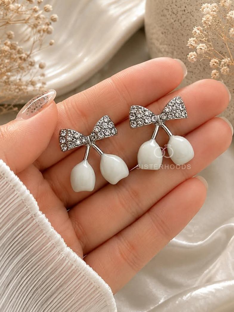 Silver bow earrings with white dangling drops | SISTERHOODS-SHA256:06ac72d69c90b948bb53ab9c8a93fe00d972d67b4df9ad20b718b19af8cc5b97