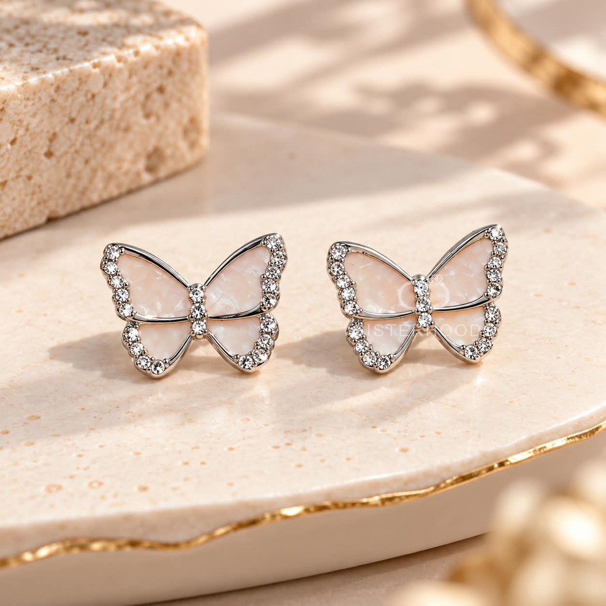 Pale pink butterfly stud earrings with sparkling silver-tone borders | SISTERHOODS-SHA256:beb443f29a8a85814870519b4bb53778ebc65c2c4b3a46f24cc4643e0d9089c4