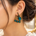 Ornate peacock motif dangle earring with teal accents and black detailing | SISTERHOODS-SHA256:e68da27bf1460c9a1af9bd3b678034e2ee1045516b3a1ad28654282ffb1d455e
