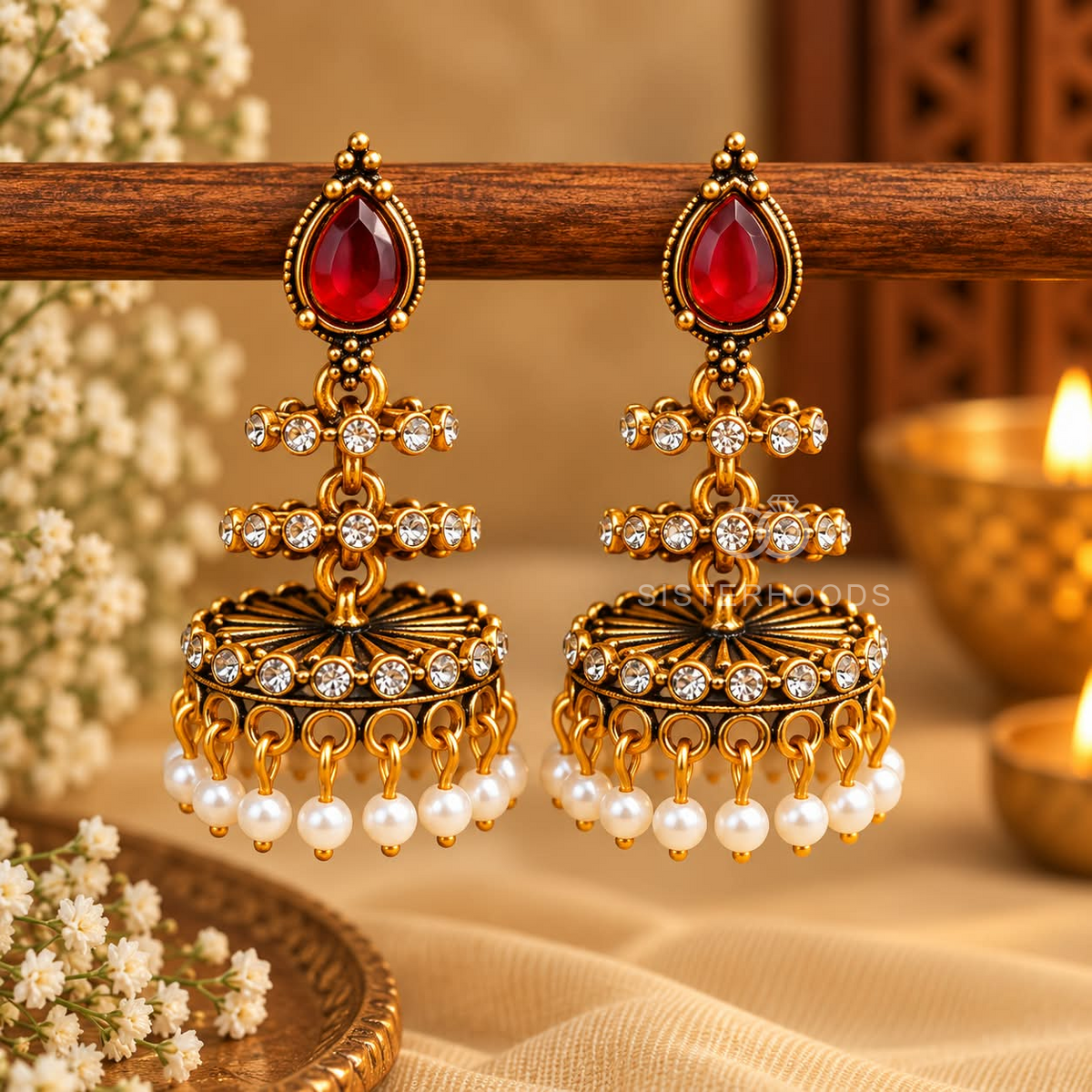 Gold-tone jhumka earrings with red teardrop accents, clear stones and white pearl drops | SISTERHOODS-SHA256:9696a1f11d06a8ca7dbff50c5c629adaba691242bb02712bff6c8e7b53a757b9