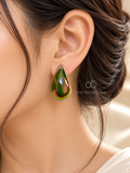 Glossy green teardrop stud earring worn on an ear | SISTERHOODS-SHA256:6a13c2022792ebe5dcb3c1b408da1929d06f1099a1d4d77bc5d5d974ec963b1e