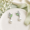 Silver-tone leaf-shaped drop earrings with green accents and round white bead drops | SISTERHOODS-SHA256:ca6a1ad43efc1e6de83512fb1a5b57673112b6884d27ddc428d528b38230e641