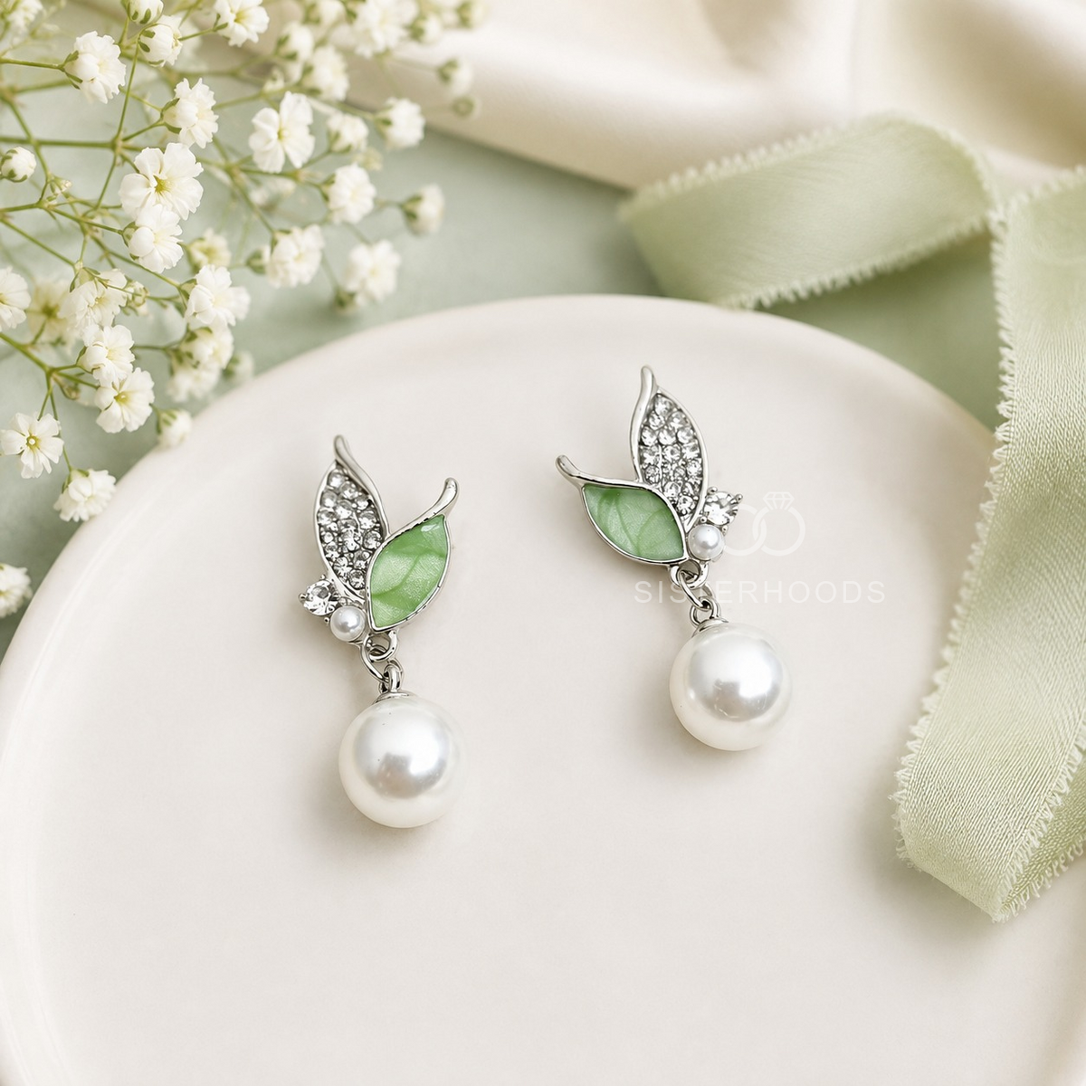 Silver-tone leaf-shaped drop earrings with green accents and round white bead drops | SISTERHOODS-SHA256:ca6a1ad43efc1e6de83512fb1a5b57673112b6884d27ddc428d528b38230e641