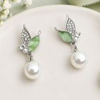 Silver-tone leaf-shaped drop earrings with green accents and round white bead drops | SISTERHOODS-SHA256:a247159ab3426cda1f37ccba21bd26b1c65b7ba6190f008290789f616201b6d0