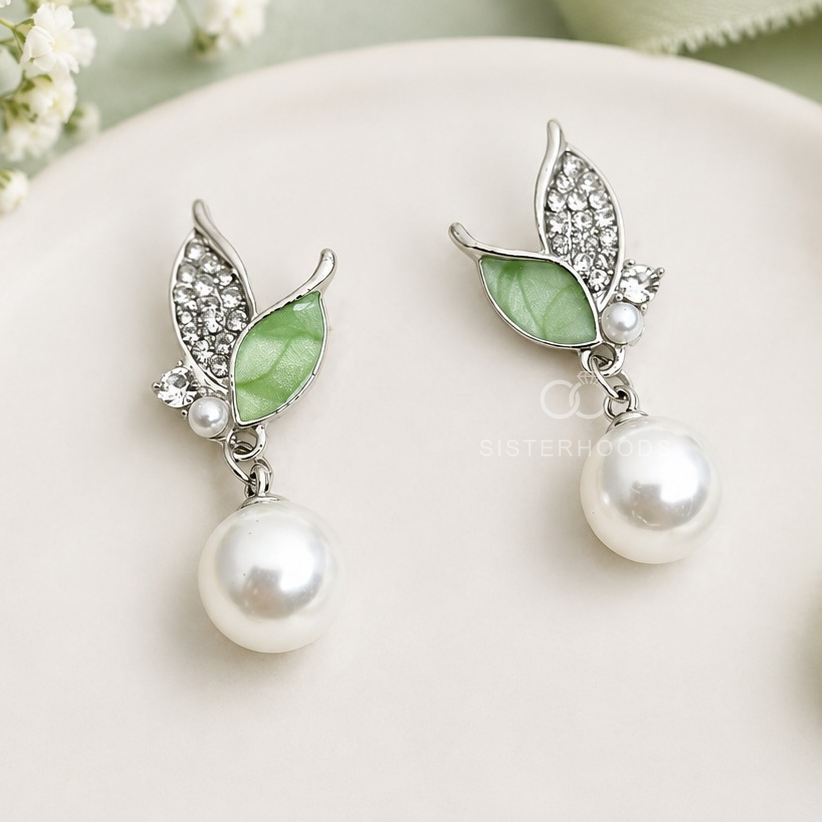 Silver-tone leaf-shaped drop earrings with green accents and round white bead drops | SISTERHOODS-SHA256:a247159ab3426cda1f37ccba21bd26b1c65b7ba6190f008290789f616201b6d0