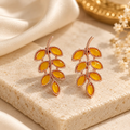 Leaf-shaped stud earrings with amber-toned accents and a rose-gold-toned finish | SISTERHOODS-SHA256:9abc4b17a0c019e130d25fbd91e9f9c295465e8270da957142e4789bbc553cab