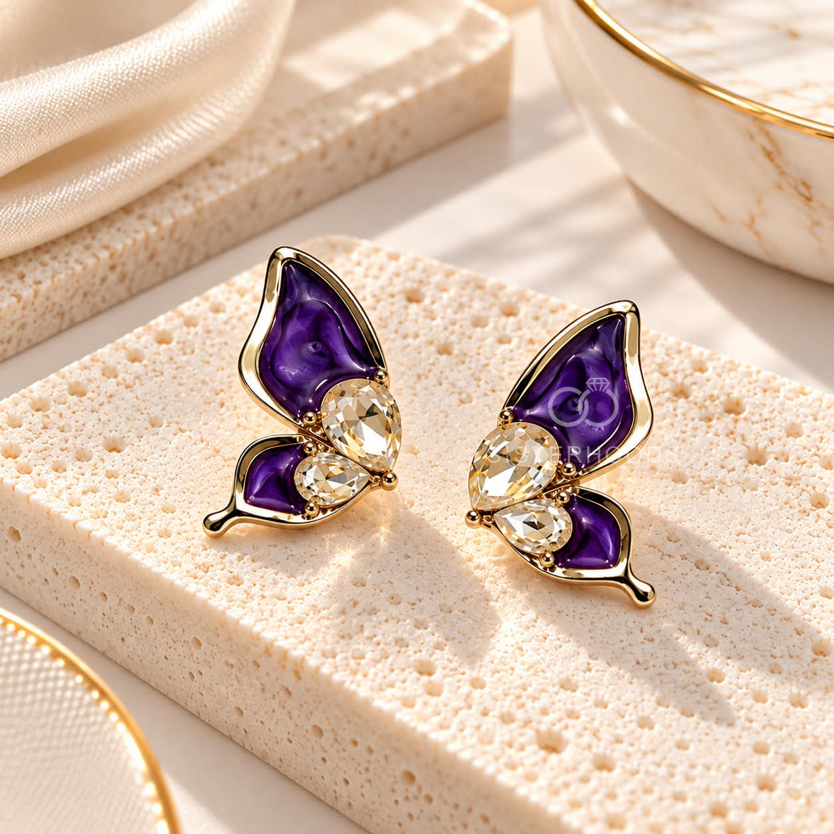 Purple wing-shaped stud earrings with faceted accents and gold-tone detailing | SISTERHOODS-SHA256:53b10aed9f0da13809a693eac8a05d0c1a29e44e0e724f32177f1348312abec2