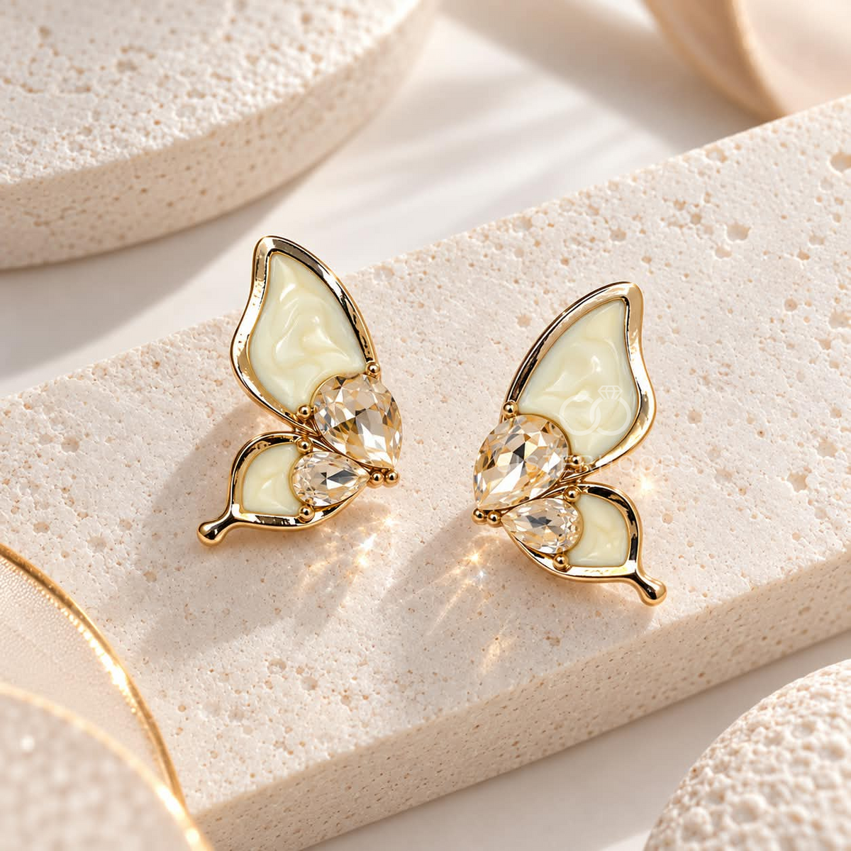 Gold-coloured butterfly stud earrings with cream wings and faceted clear accents | SISTERHOODS-SHA256:9db7d92af2b9f49d1a9fa989f0c085402930493560c3fa9814d52f8dce9fa6b6
