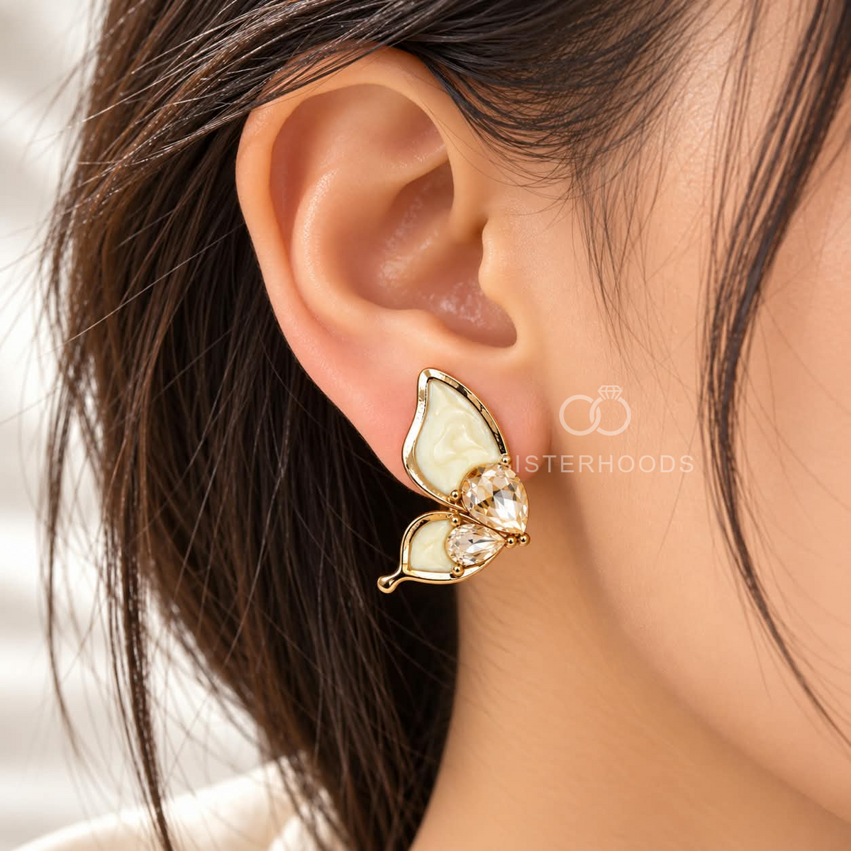 Gold-coloured butterfly stud earrings with cream wings and faceted clear accents | SISTERHOODS-SHA256:09b6c5a925bc880d115e93b76549e6d6db907fa36d8ba45533fa3e9113f094d4